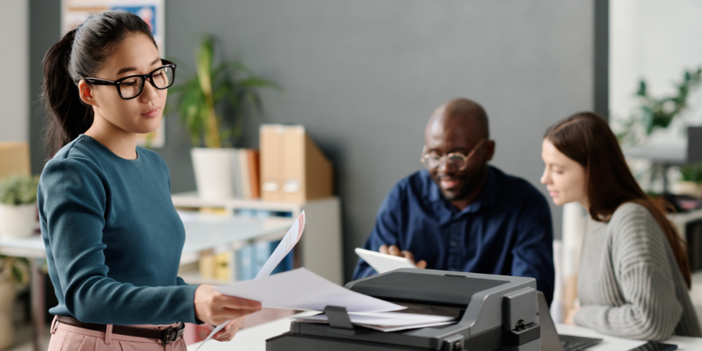 Persone in ufficio che controllano dei documenti stampati